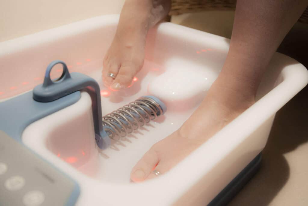 Frau badet Ihre Füsse im Elektrolysenfussbad
